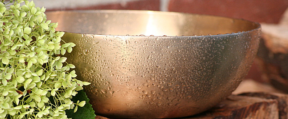 Klangschale mit blume auf einem Holzstapel