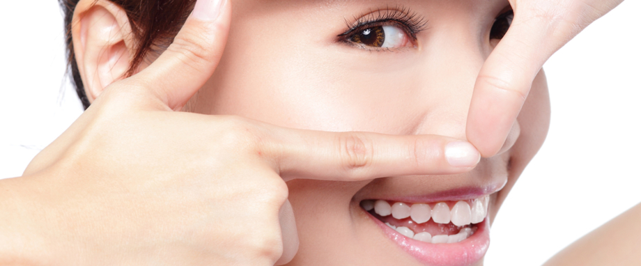 Frau, die ihr Auge mit den Fingern einrahmt